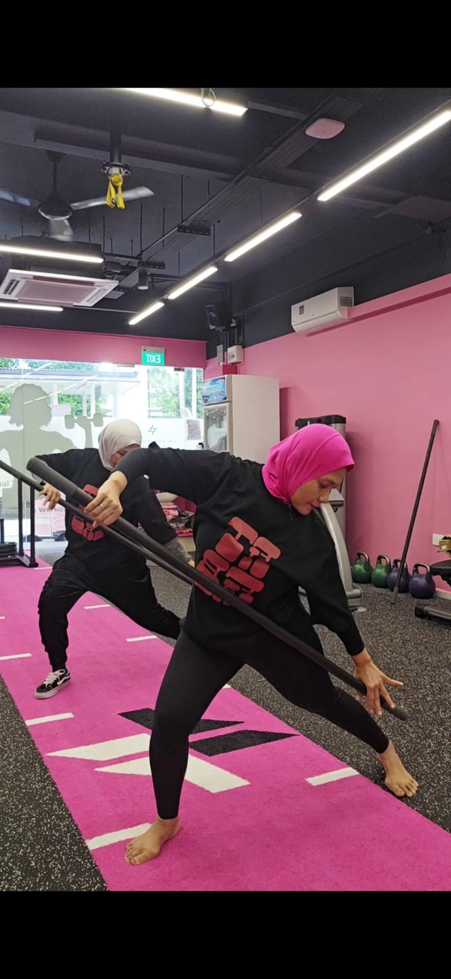 FitFab.sg members in a stick mobility class on the pink turf